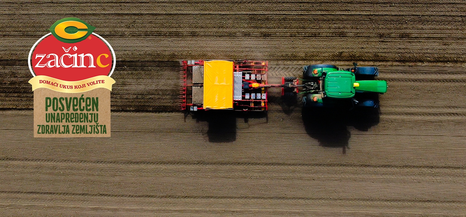 A tractor is driving across the field and sowing seeds.